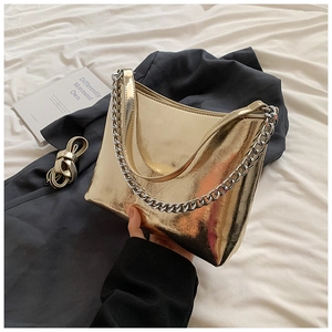 Détail du sac à main doré effet miroir froissé avec sa chaîne épaisse en argent métal