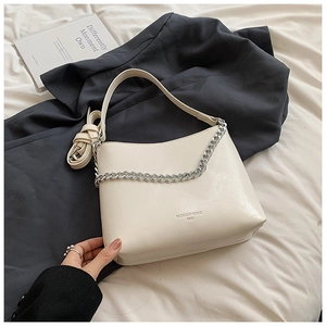 Détail d'un sac à bandoulière en cuir blanc crème avec chaîne argentée et longue sangle