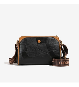 Detail der Boston-Tasche mit schwarzem genarbtem Leder-Patchwork und breitem Riemen