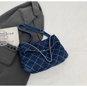 Dettaglio ravvicinato della borsa a tracolla in denim blu scuro con cuciture a rombi