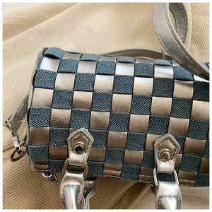 Close-up of checkered pillow bag showing denim and silver leather woven details