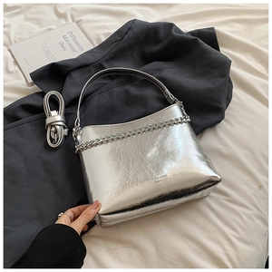 Détail d'un sac à main argenté métallisé avec texture craquelée et chaîne stylée