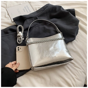 Détail du sac seau argenté métallisé avec texture plissée et chaîne élégante