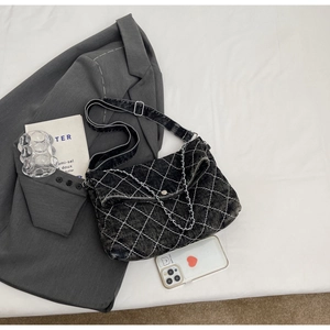 Dettaglio della borsa in denim grigio con trapuntatura a rombi e confronto taglia