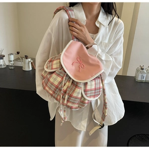 Détail du sac à dos en toile à carreaux avec broderie nœud rose et cordon de serrage