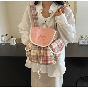 Close-up of pink plaid backpack featuring a cute bow detail and drawstring closure