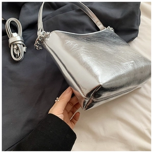 Vue détaillée du sac argenté métallisé avec texture plissée et bandoulière amovible