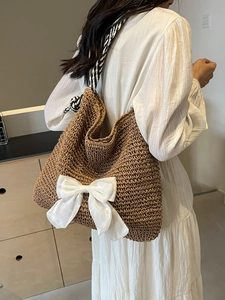 Large straw tote bag with white bow and rope strap for summer beach holidays