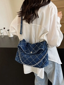 Borsa tote in denim trapuntato con catena argento e tracolla larga su modella