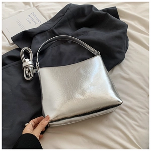 Détail du sac bandoulière argenté métallisé avec double bandoulière sur fond chic