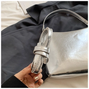 Détail du sac hobo argenté avec bandoulière amovible et finition métallique brillante