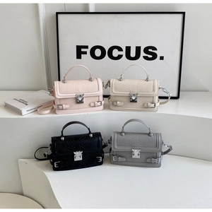 Detail of four textured crossbody bags in pink, beige, black, and grey with top handles