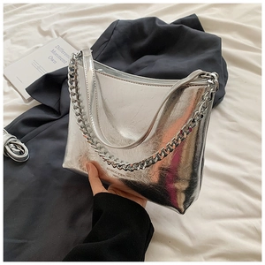 Détail du sac à main argenté métallisé avec chaîne élégante et logo de marque