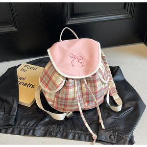Détail du sac à dos à carreaux rose avec broderie nœud papillon et fermeture à cordon