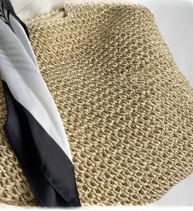 Detailed close-up of natural straw weave texture with decorative black and white silk scarf