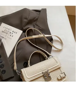 Close-up of cream crocodile pattern leather bag featuring a silver butterfly metal buckle