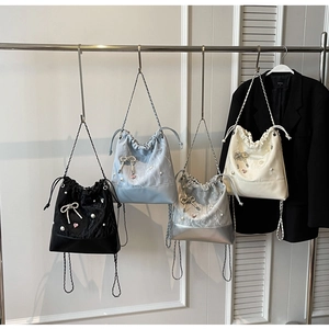Detailed display of four drawstring bucket bags in black, blue, silver, and cream colors