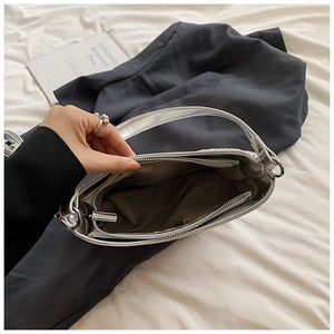 Vue intérieure du sac argenté en demi-lune montrant les compartiments et la fermeture