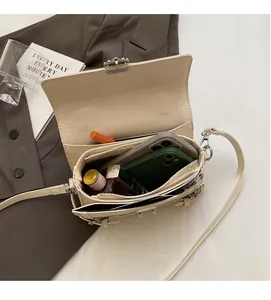 Interior view of beige leather crossbody bag showing functional pockets and compartments