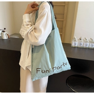 Vue latérale détaillée d'un grand sac fourre-tout en toile vert clair avec texte Fun Party