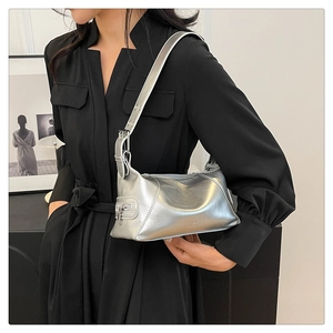 Detail of silver metallic underarm bag with adjustable buckle strap and brand logo