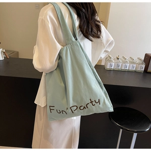 Vue détaillée du sac cabas en toile vert clair avec inscription Fun'Party et sangle