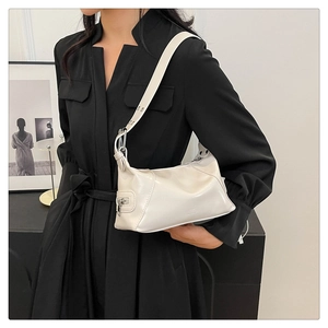 Detail of minimalist cream PU leather hobo bag with wide grommet strap on model