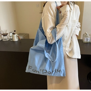 Sac cabas en toile bleu clair avec imprimé Fun'Party dans un décor de café décontracté