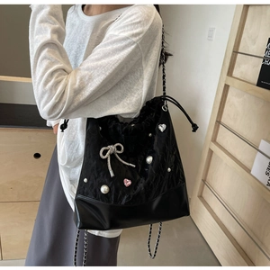 Detail of black drawstring bucket bag with pearls, pink heart rhinestones and silver chain
