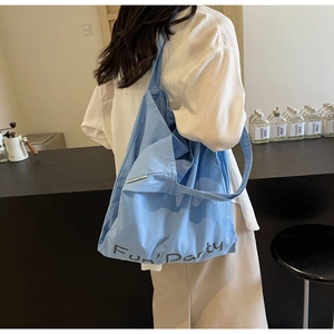 Détail du sac fourre-tout en toile bleu clair montrant l'imprimé et la poche avant