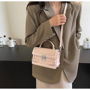 Detail of apricot pink crocodile pattern crossbody bag with metal animal clasp