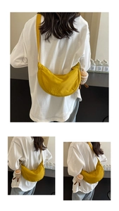 Gros plan détaillé d'un sac demi-lune jaune vif en nylon avec un petit pendentif peluche