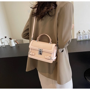 Detail of pink crocodile embossed crossbody bag showing silver buckle and shoulder strap