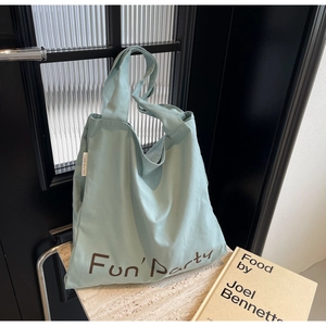 Gros plan du sac fourre-tout en toile bleu clair avec lettrage marron Fun Party