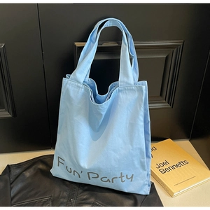 Détail du sac fourre-tout en toile bleu clair avec imprimé Fun Party et doubles poignées