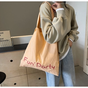 Détail du sac cabas en toile abricot avec imprimé Fun Party rouge et bandoulière