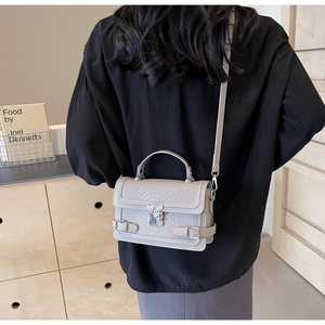 Close-up of gray faux leather crossbody bag with snake-embossed texture and silver clasp