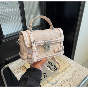 Detail of pink faux crocodile leather handbag with silver clasp and top handle