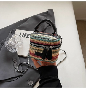 Detail of colorful woven mini bag with silver chain strap and dual zipper closure