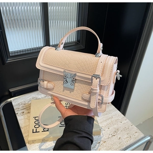 Detail of light pink crossbody bag with embossed leather texture and silver buckle
