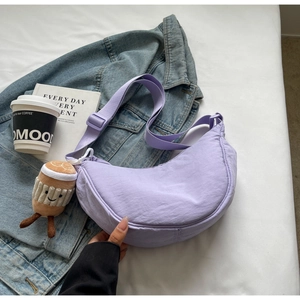 Détail du sac dumpling en nylon violet avec bandoulière réglable et breloque peluche café
