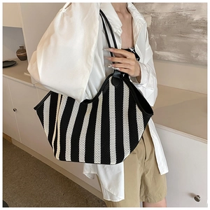 Detailed view of large black and white striped woven mesh tote bag with leather straps