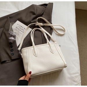 Close-up of white litchi pattern tote bag showing high-quality synthetic leather and straps