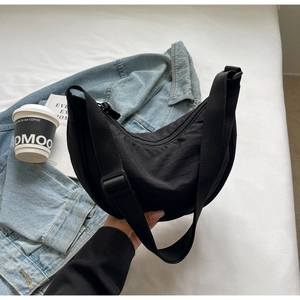 Détail du sac bandoulière en nylon noir avec sangle ajustable pour look décontracté