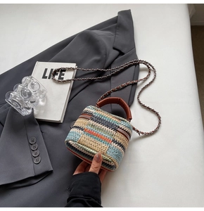 Detailed overhead view of a rainbow straw weave mini bag on a grey blazer outfit