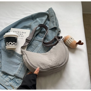 Détail du sac bandoulière croissant en nylon gris avec sangle réglable en décor décontracté