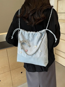 Blue bucket backpack with silver chain, rhinestone bow, and heart charm detail