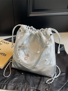 Silver bucket bag with marble texture, pearl accents, and rhinestone bow detail