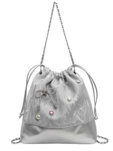 Silver metallic bucket bag with pearl accents and rhinestone bow on a white background