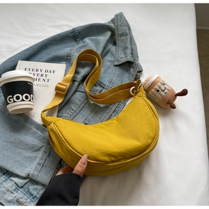 Détail d'un sac demi-lune jaune gingembre en nylon avec bandoulière réglable